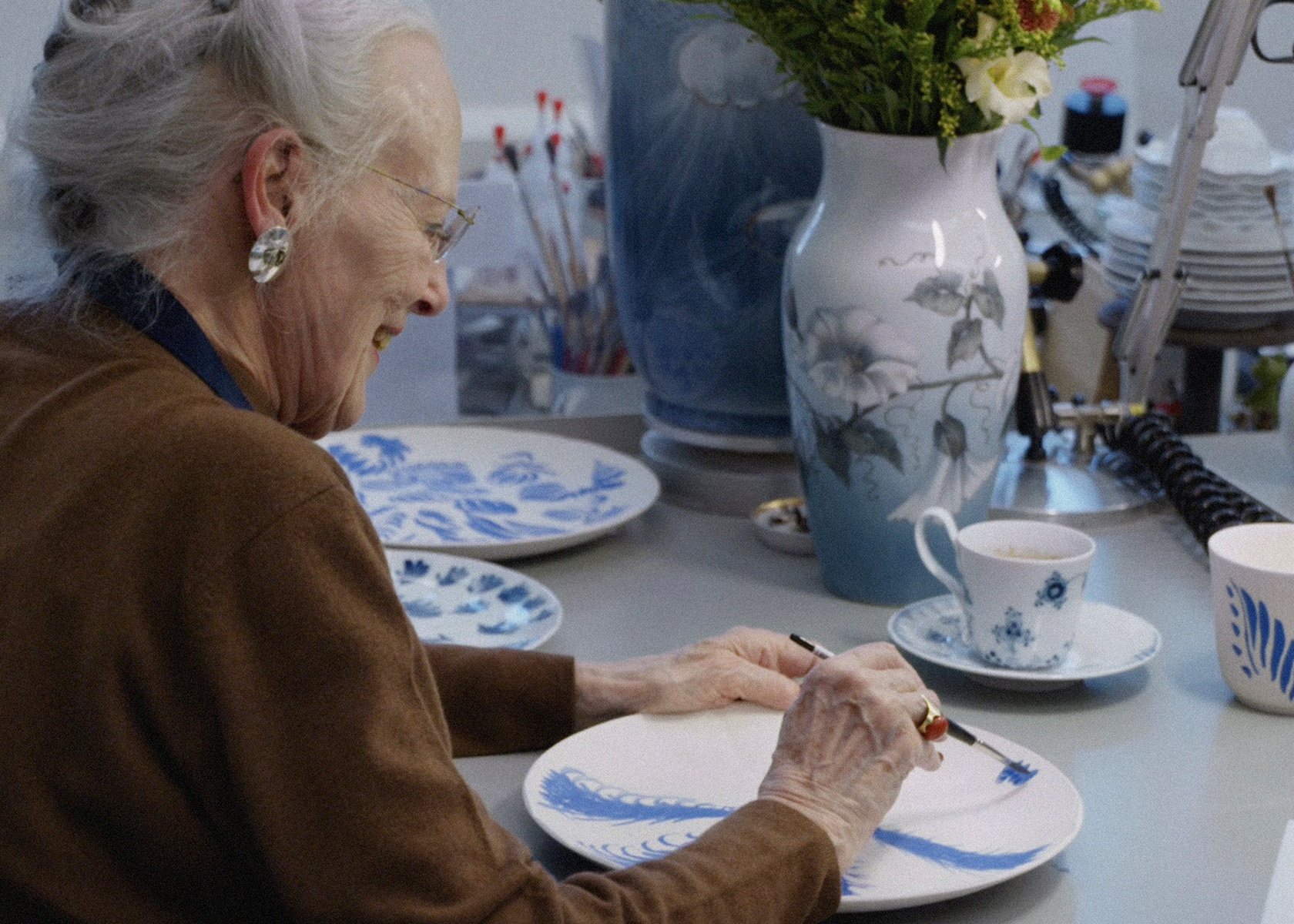 Her Majesty Queen Margrethe of Denmark is painting on porcelain.